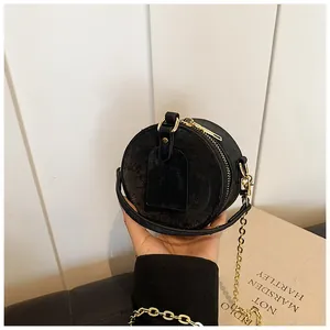 Vista detallada de un mini bolso bandolera redondo negro para niños con cadena