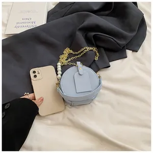 Mini bolso bandolera redondo azul claro para niñas con elegante cadena dorada y perlas