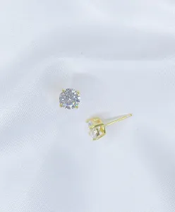 Detailed view of sparkling four-claw cubic zirconia stud earrings in gold finish