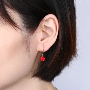 Close-up of red Shamballa crystal ball earrings with S925 silver hooks on ear