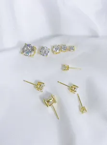 Detail view of various sizes of gold plated four-prong cubic zirconia stud earrings.