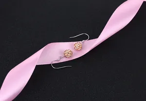 Close-up detail of sparkling champagne crystal Shamballa ball earrings on silver hooks