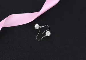 Close-up detail of sparkling S925 silver crystal ball drop earrings on elegant black surface