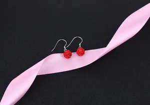 Detail of red crystal ball drop earrings with S925 sterling silver hooks on pink ribbon