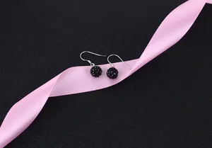 Detailed view of silver hook earrings with black faceted Shamballa crystal balls.