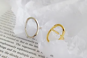 Detailansicht von minimalistischen unregelmäßigen offenen Ringen in Gold und Silber.