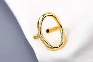 Nahaufnahme eines goldfarbenen unregelmäßigen geometrischen offenen Rings mit Textur