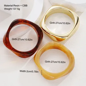 Detail view of chunky resin and gold metal bangles showing dimensions and material specs.