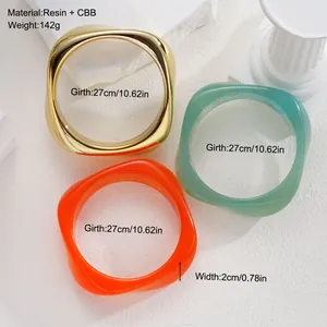 Detail view of resin irregular bangles in gold, green, and orange with size parameters.