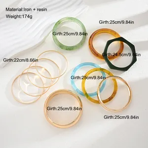 Detail view of mixed resin and metal bangle set with size and material specifications