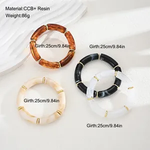 Detail shot of four chunky resin bracelets in marbled brown, cream, black, and white