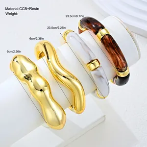 Detailed view of chunky irregular gold and marbled resin bangles with dimensions