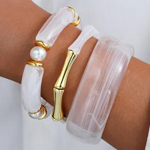 Chunky white acrylic bracelet set with gold bamboo bangle and textured resin cuff for women