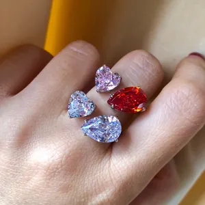 Primer plano de anillos de plata S925 con piedras talladas en forma de corazón y pera.