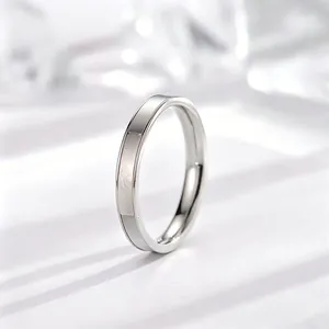 Detailweergave van een minimalistische titanium stalen ring met witte schelpinleg