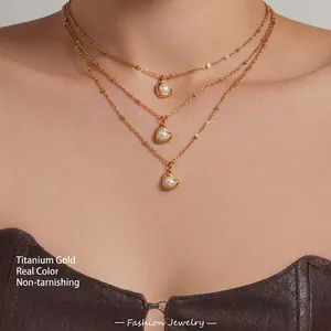 Detalle de cerca de un collar de tres capas en oro con corazones y perlas