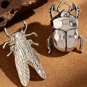 Exquisite detail close-up of vintage silver metal beetle and cicada insect-shaped rings.