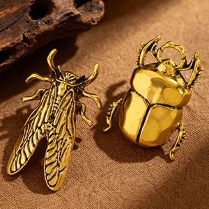 Close-up detail of vintage gold-finished metal beetle and cicada insect rings