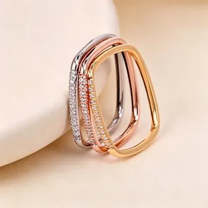 Gros plan de trois bagues carrées superposées avec cristaux micro-pavés en or et argent.