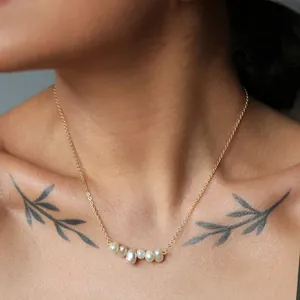 Close-up of 18k gold plated titanium steel necklace with 5 natural freshwater pearls.