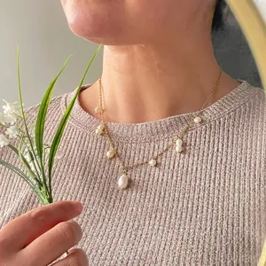 Close-up of elegant natural freshwater pearl necklace on model with pink ribbed sweater