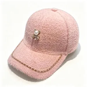 Detail of pink plush baseball cap featuring pearl bear and rhinestone chain decoration