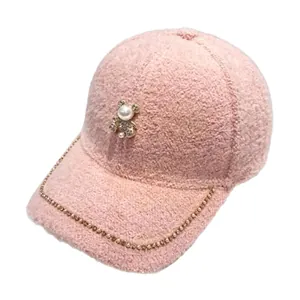 Stylish pink plush baseball cap featuring a pearl bear ornament and rhinestone chain brim