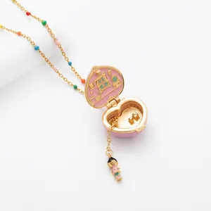 Detail view of an open pink heart locket necklace revealing a miniature dollhouse interior