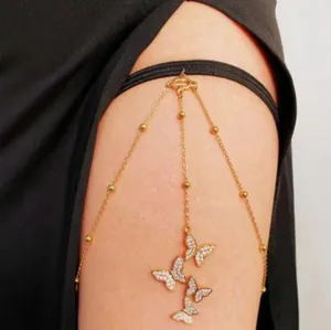 Detailansicht einer goldenen Schmetterlingsbeinkette mit funkelnden Kristallanhängern