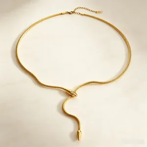 Gros plan d'un collier serpent doré en titane avec tête ornée de cristaux