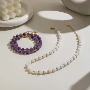 Detailed view of faceted amethyst and white natural stone necklaces with gold chains