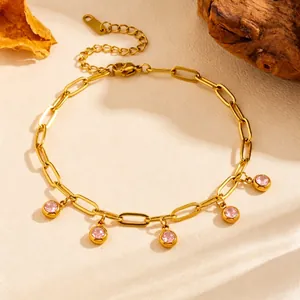 Detailed view of gold PVD titanium steel anklet with dangling pink zircon charms.