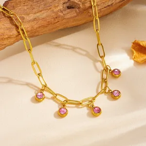 Detailed macro view of gold titanium steel chain necklace with five pink crystal stone charms.