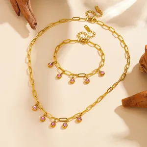 Detailed view of gold plated stainless steel jewelry set with pink stones charms