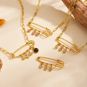 Close-up of gold-plated titanium steel safety pin necklaces with vibrant zirconia gems