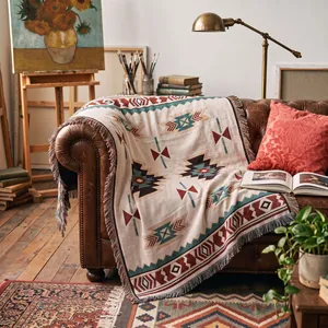 Jeté de canapé tissé bohème avec franges disposé sur un canapé en cuir vintage