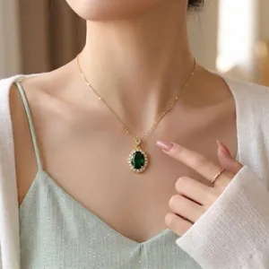 Close-up of elegant emerald green zircon pendant on a gold-plated titanium steel chain