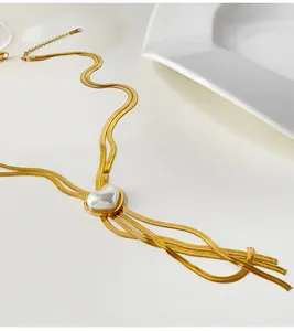 Vue détaillée d'un collier double couche en acier titane doré avec pendentif cœur perle.