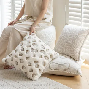 Detailed lifestyle shot of cream-style decorative pillows with textured patterns