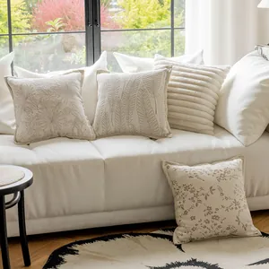 Detailed view of cream style decorative pillow covers with elegant leaf and floral patterns