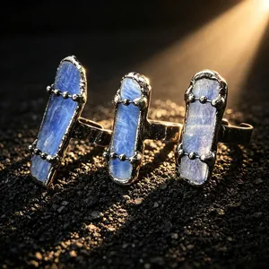 Close-up macro detail of vintage silver rings with raw blue kyanite stones and bead chain accents