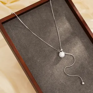 Detail van een verstelbare roestvrijstalen lariat ketting met een elegante witte parel