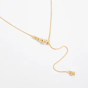 Detailopname van de verstelbare goudkleurige rvs-ketting met kleine gouden kralen