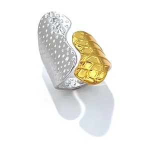 Détail d'une bague bicolore en acier inoxydable avec des textures dorées et argentées