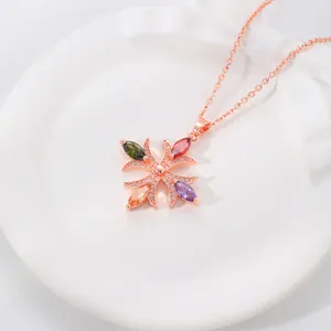 Primo piano dettagliato della collana con croce in oro rosa e zirconi marquise colorati