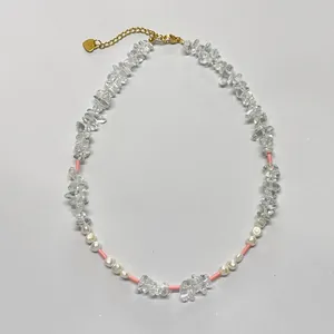 Détail d'un collier de pierres claires et perles d'eau douce avec chaîne dorée