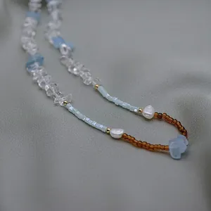 Gros plan détaillé des pierres bleues irrégulières et des perles d'eau douce d'un collier