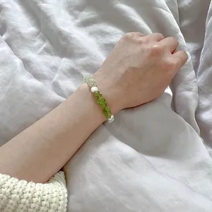 Détail d'un bracelet perlé fait main en pierre verte concassée et perles d'eau douce au poignet