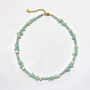 Détail d'un collier artisanal avec des pierres vertes et des perles d'eau douce