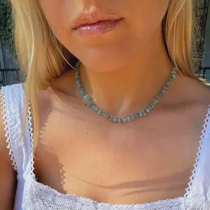 Gros plan d'un collier de perles en pierre naturelle irrégulière sur le cou d'un mannequin